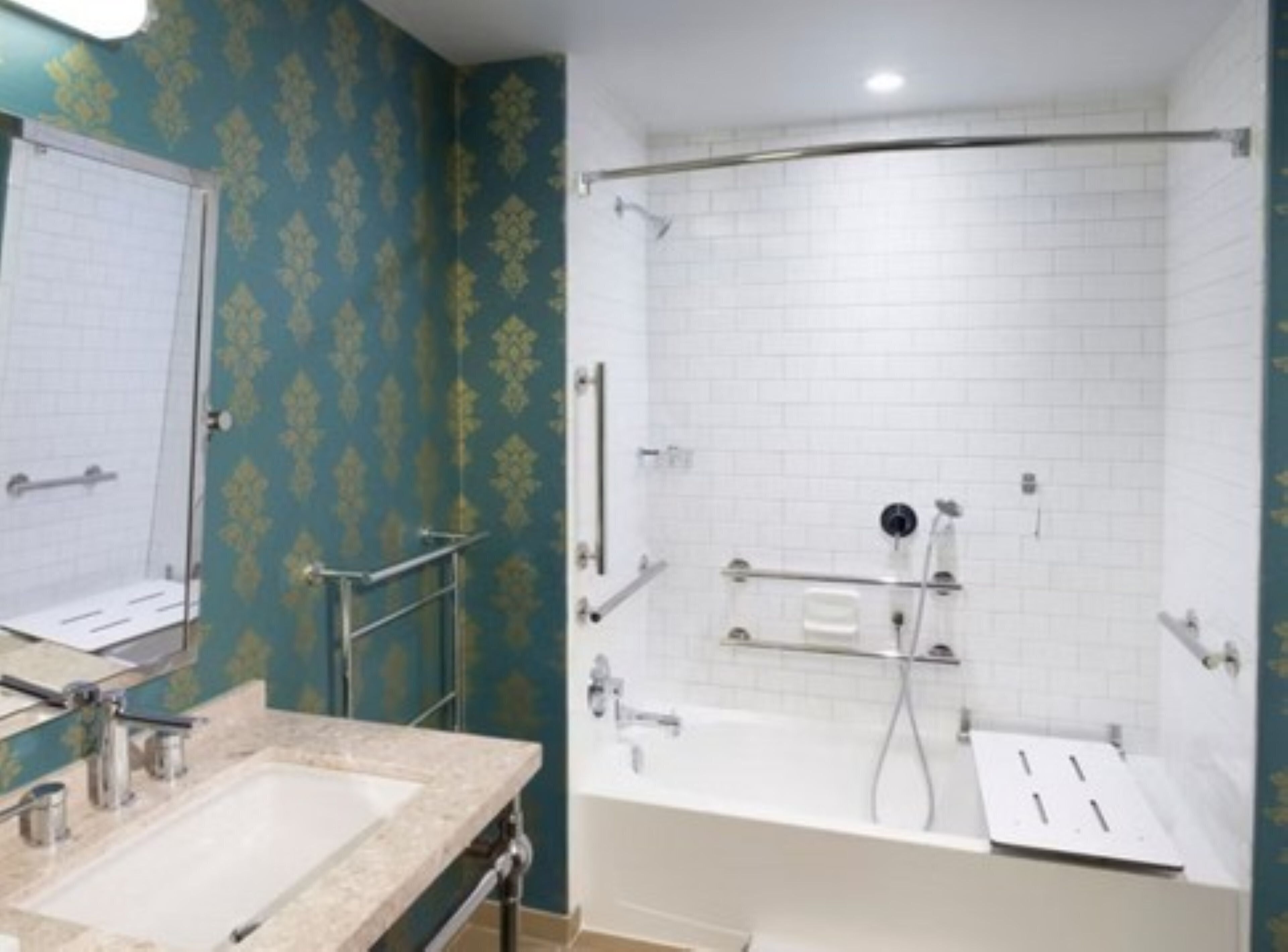 A bathroom with a bathtub, a shower, a sink, and a mirror.