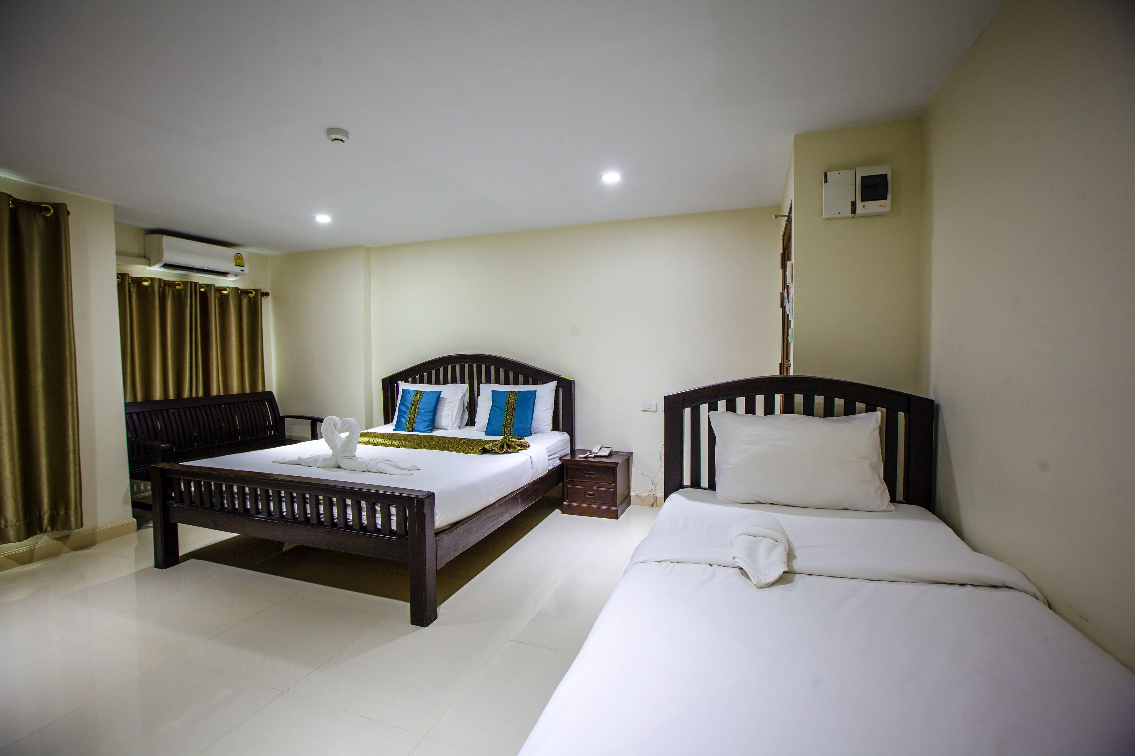Una habitación de hotel con dos camas, un escritorio y un equipo de aire acondicionado.