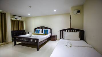 Una habitación de hotel con dos camas, un escritorio y un equipo de aire acondicionado.