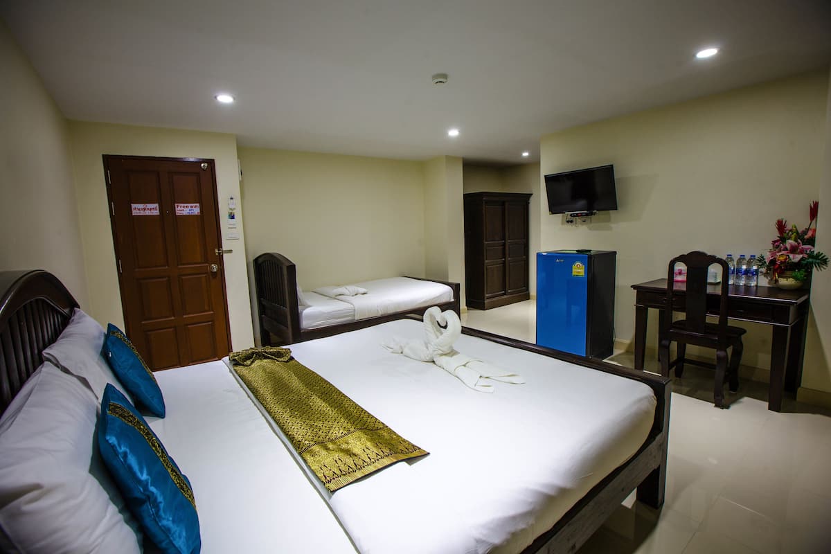 Een hotelkamer met twee éénpersoonsbedden, een bureau met stoel, een televisie en een minibar.