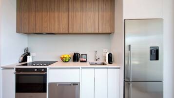 A modern kitchen with wooden cabinets, stainless steel appliances, and a tiled backsplash.