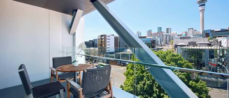 Un balcón con vistas a un horizonte urbano, incluyendo una torre destacada.