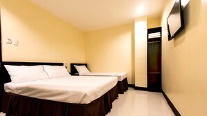 A hotel room with two beds, a wardrobe, and a mirror on the wall. - Winzelle Suites (Zamboanga)