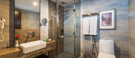 A modern bathroom with a glass-enclosed shower, a sink with a marble countertop, and a toilet.