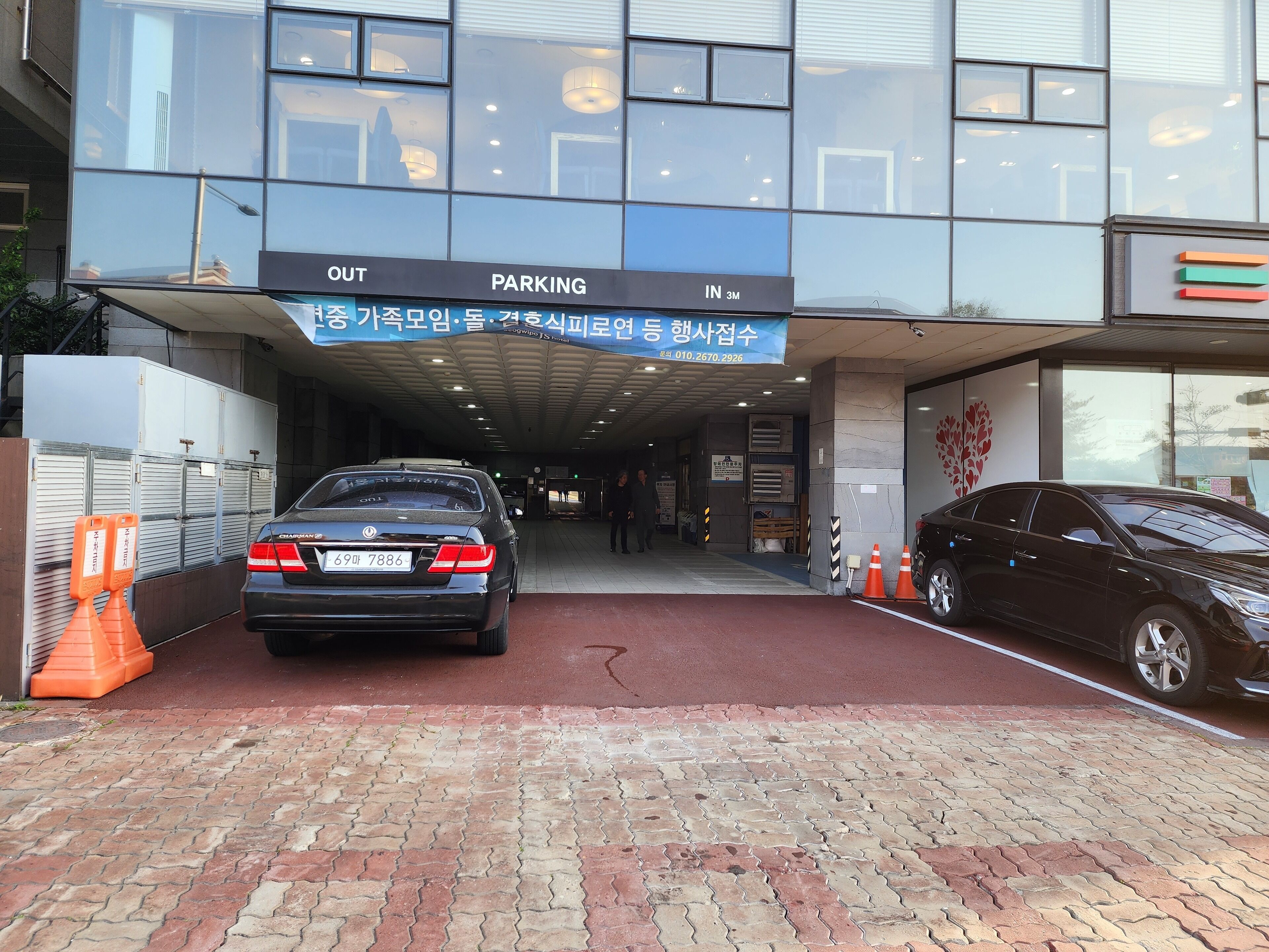 A hotel entrance with a sign indicating parking areas.