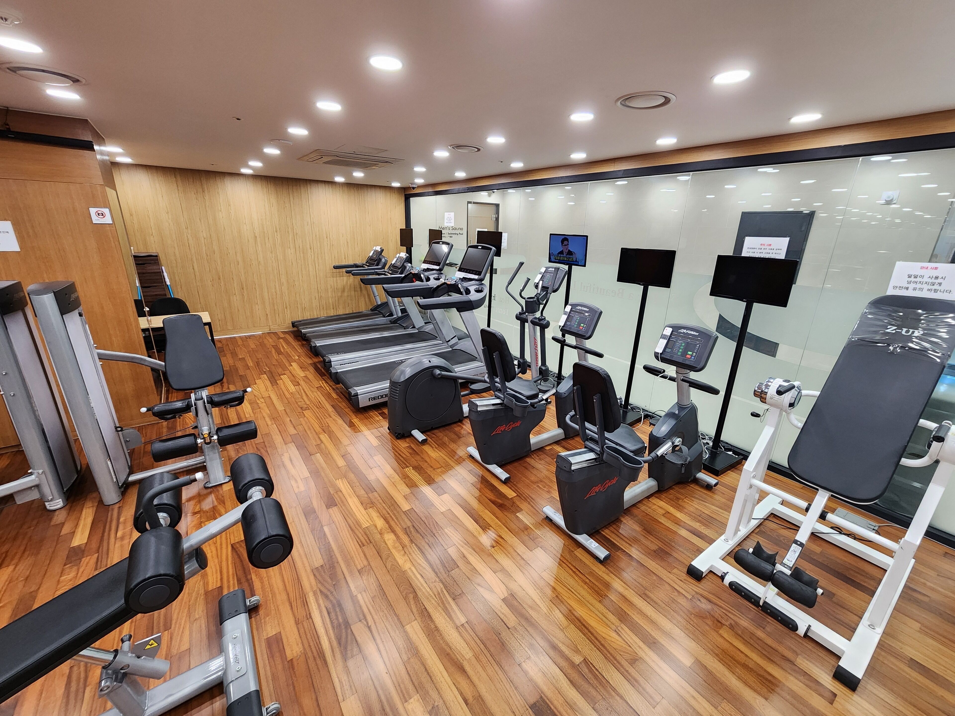 A gym with treadmills, elliptical machines, and weightlifting equipment.