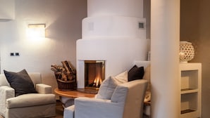 Una sala acogedora con chimenea, dos sofás y una mesita auxiliar.
