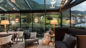 Una habitación moderna con techo de vidrio, un sofá, una mesa y dos lámparas.