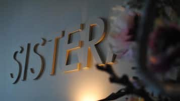A wall with the word "SISTER" in a modern, three-dimensional font.