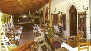 Une auberge traditionnelle avec des poutres en bois, des murs blancs et un bar central.