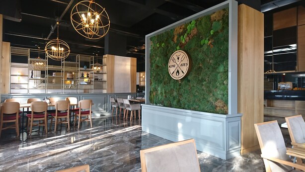 Ein modernes Interieur mit Barbereich, Sitzgelegenheiten und einer Wand mit einer Uhr.