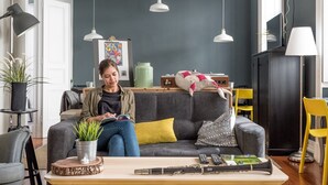 Een moderne woonkamer met een bank, een salontafel en hanglampen.