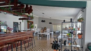 A spacious cafe with a checkered floor, wooden bar, and multiple seating areas. - Parque de Campismo Orbitur Valverde (Lagos)