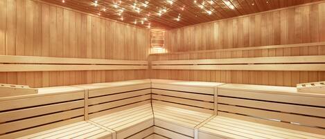Una sauna con bancos de madera e iluminación empotrada en el techo.