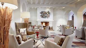 A spacious living room with a fireplace, comfortable seating, and a decorative wall art piece.