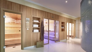 A modern spa with wooden paneling, a sauna, and a large tiled wall. - Das Alpenhaus Gasteinertal (Bad Hofgastein)
