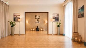 Eine Hotelhalle mit Holzboden, einer Buddha-Statue und einem motivierenden Zitat an der Wand.
