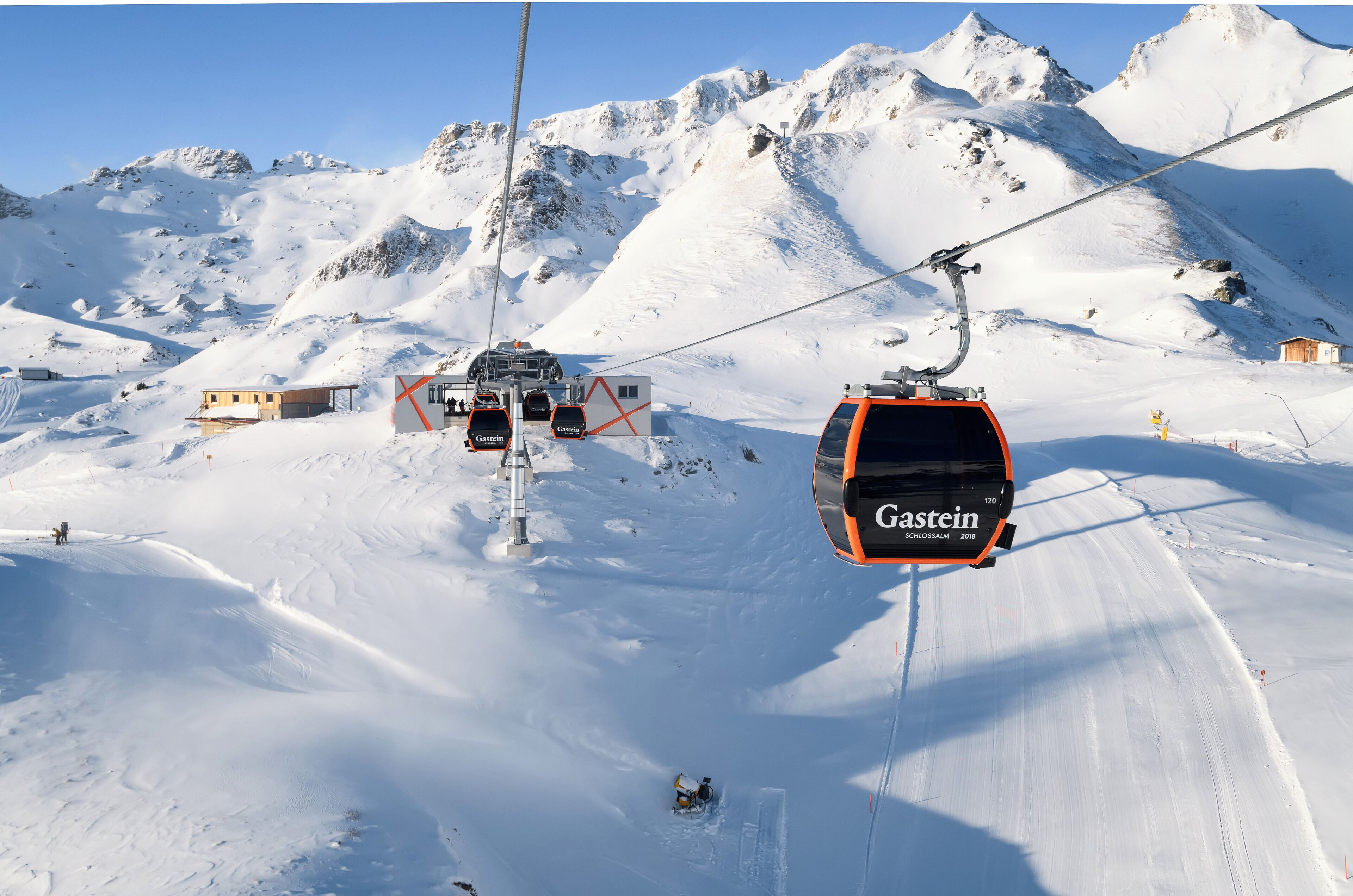 Sistema de teleférico con un telesilla marcado 'Gastein' en una zona montañosa nevada.