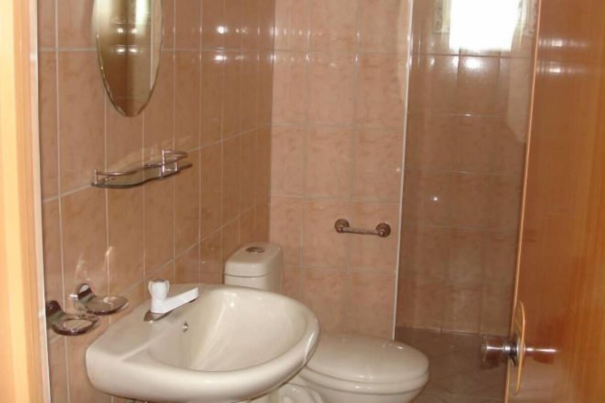 Un baño con lavamanos, inodoro y cabina de ducha de vidrio.