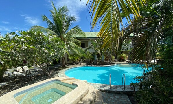 Una piscina al aire libre, sillones reclinables de piscina