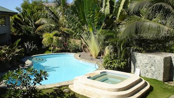 Una piscina al aire libre, sillones reclinables de piscina