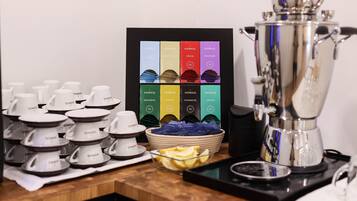 Un espace dédié au café, comprenant une machine à café, des tasses et un présentoir avec différentes saveurs de café.
