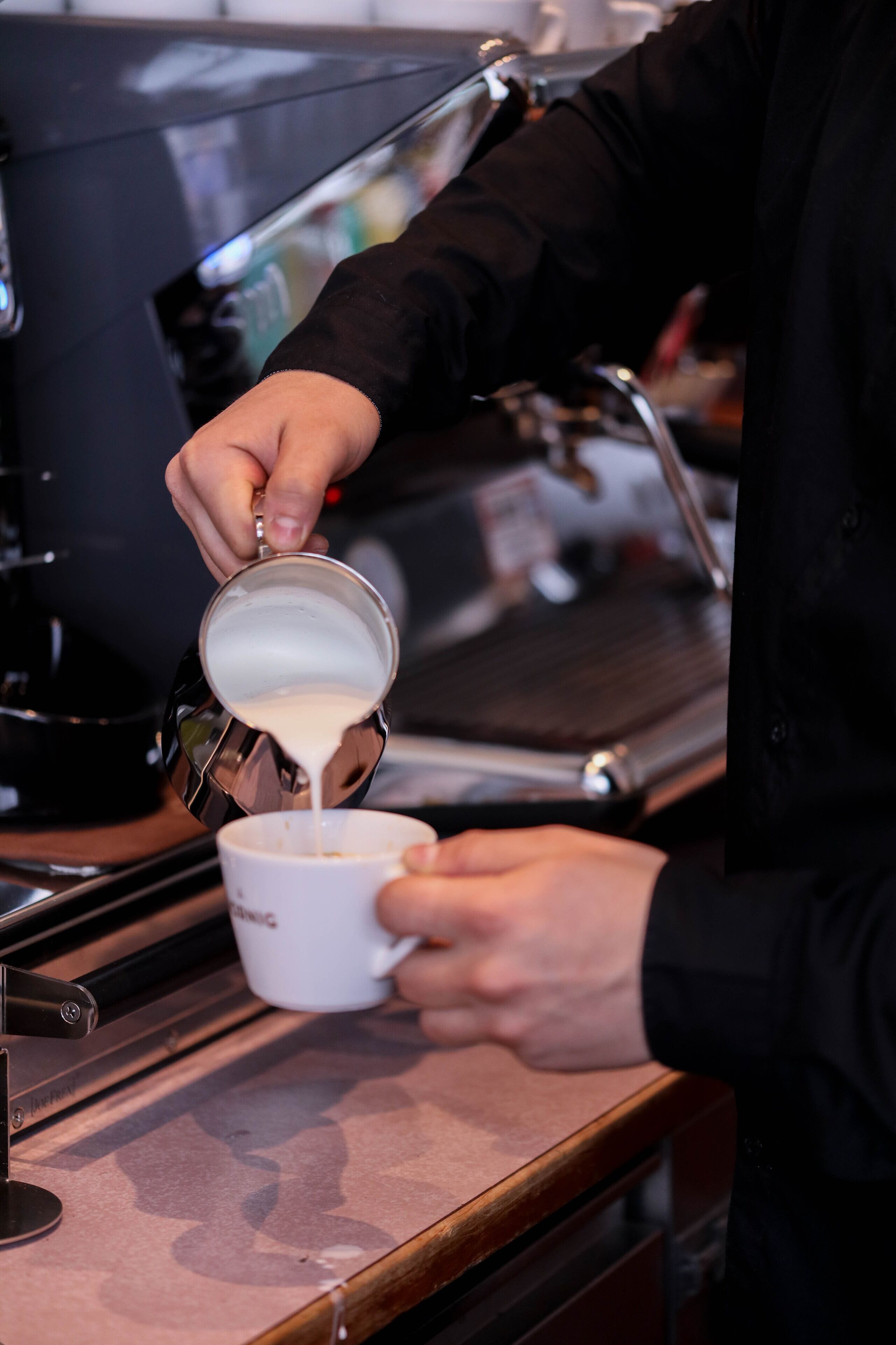 Une personne qui verse du lait dans une tasse.
