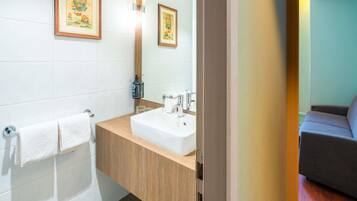 Un baño con lavabo, espejo y toallero.