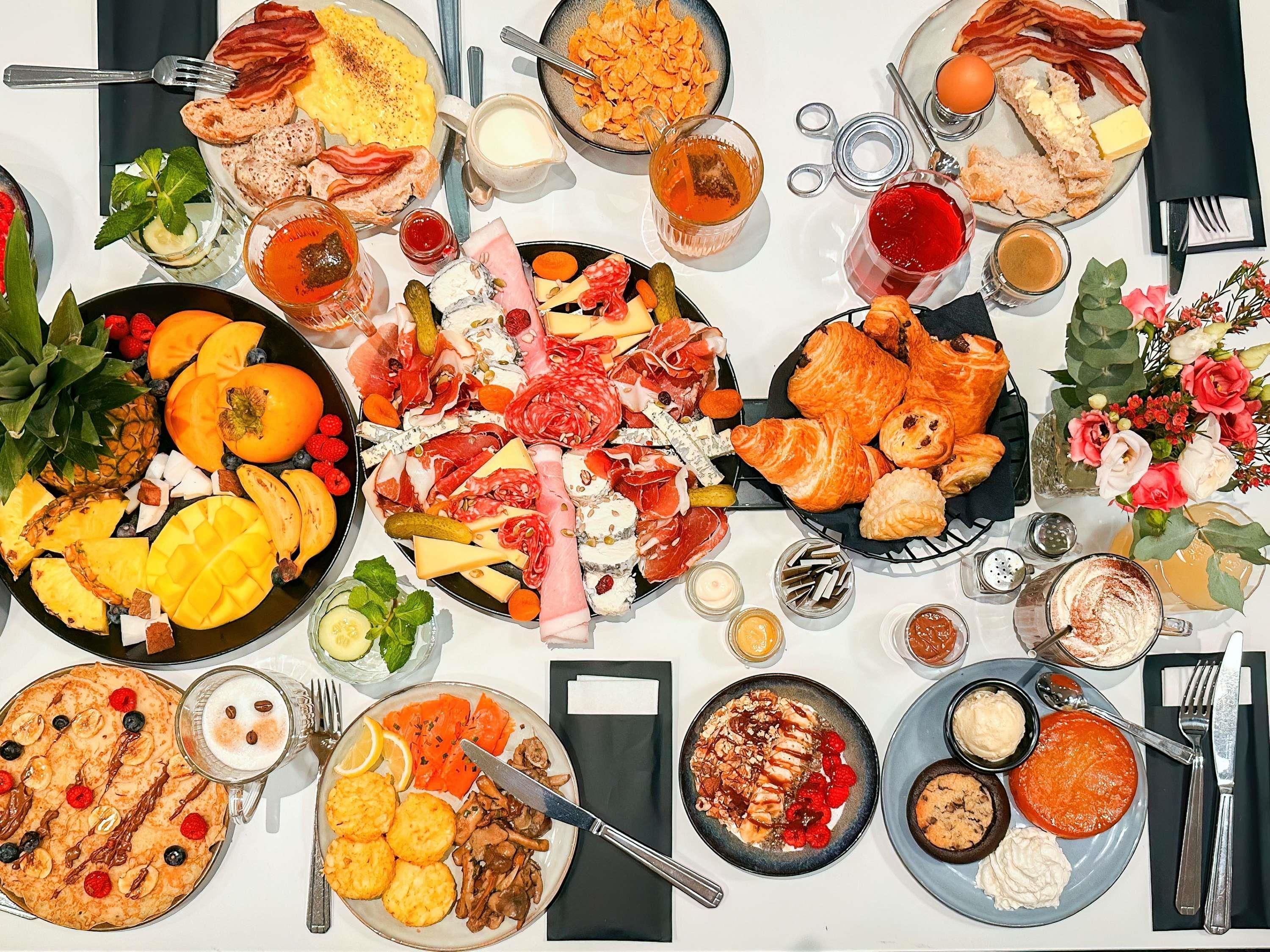 A table with various food items, plates, and utensils.