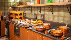 A buffet with various food items and a coffee machine.