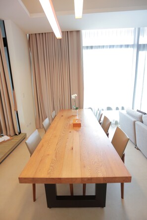 A conference room with a long wooden table, beige curtains, and a large window with natural light. - Ispavita Resort (Jiaoxi)