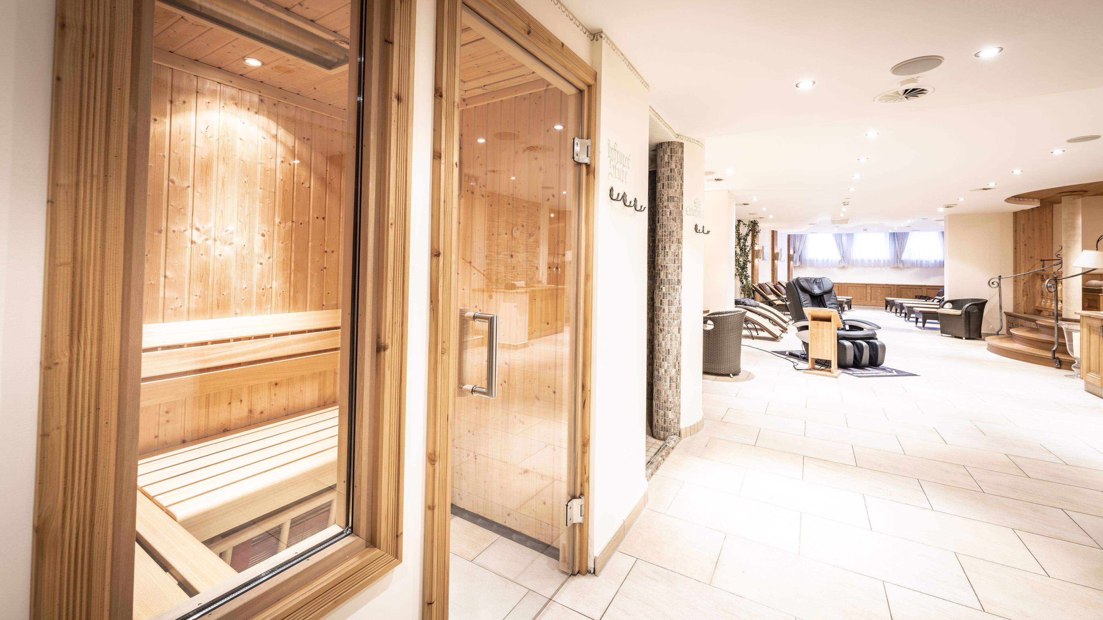 A hotel lobby with wooden paneling, a reception desk, and a seating area with massage chairs.