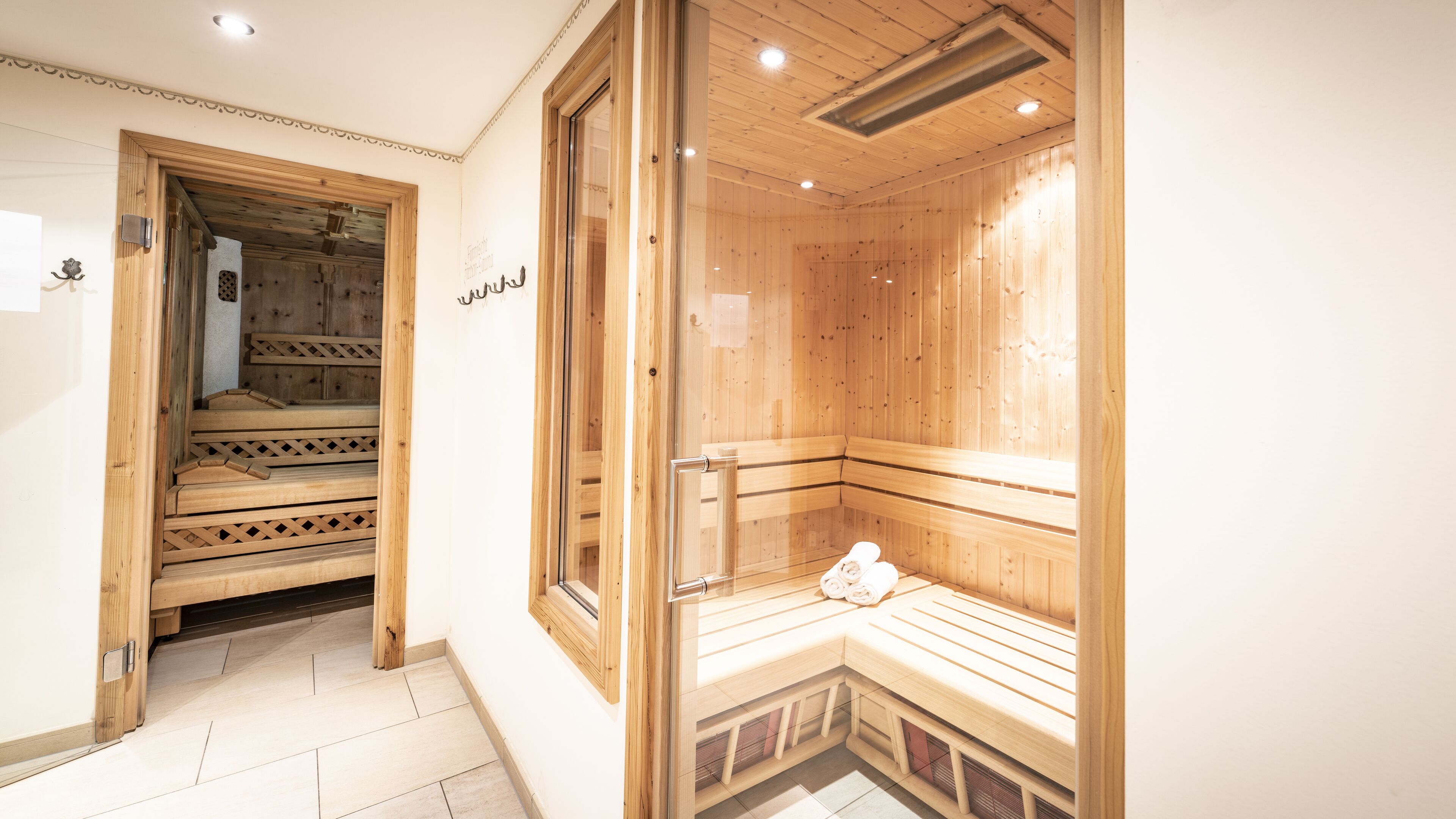 A sauna room with wooden benches and a glass door.