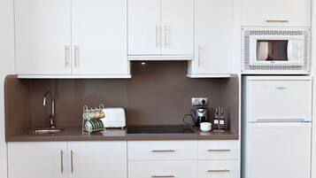 Een koelkast met diepvriezer, een microgolfoven, een kookplaat