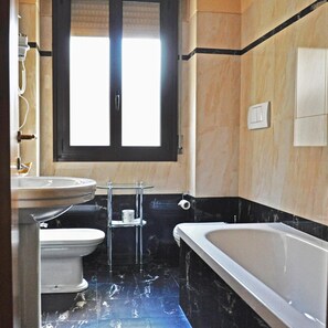 Un baño con inodoro, lavabo y bañera.