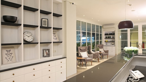 A modern kitchen with white cabinetry, black shelves, a black countertop, and a large window. - Havenwood Residence TB Simatupang (Jakarta)
