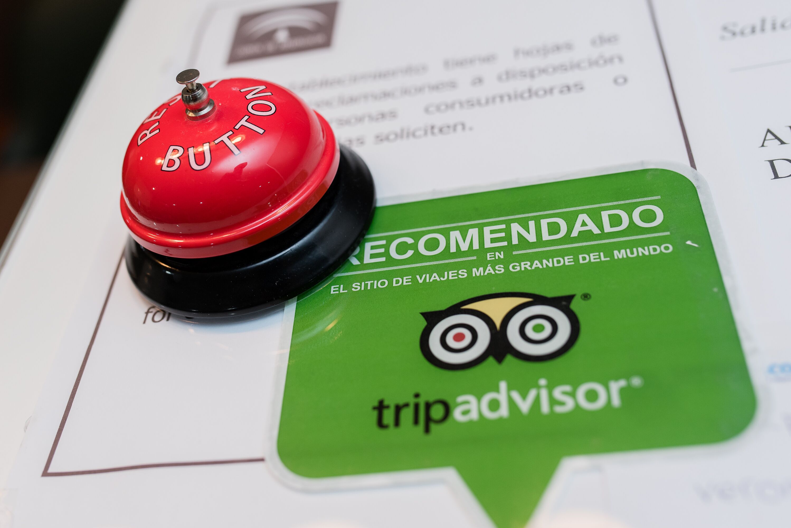 A red button labeled "RECOMMENDED" and a green TripAdvisor badge on a document.
