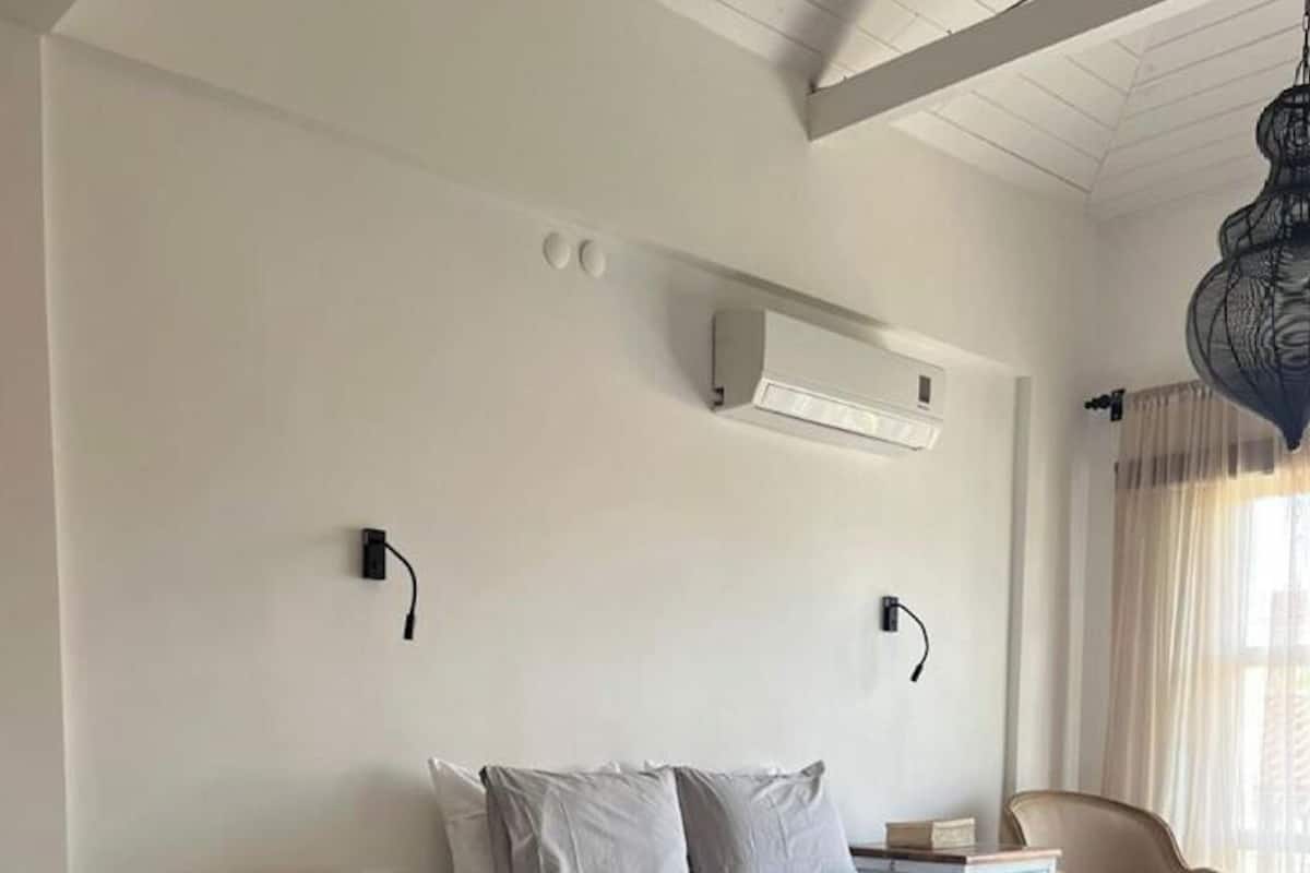 Ein Schlafzimmer mit Bett, Nachttischen, einem Kleiderschrank und einer Hängeleuchte.
