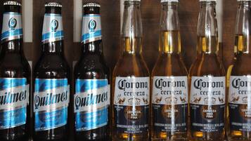 A row of beer bottles on a shelf.