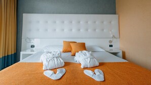 A hotel room with a white bed, orange bedding, and a grey headboard. - Hotel Viest (Vicenza)