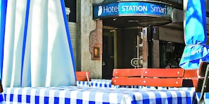 A hotel station with a blue and white checkered tablecloth, red benches, and a sign reading "Hotel STATION Smart Sta". - Smart Stay Hotel Station Munchen (Munich)