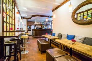 A restaurant interior with wooden tables, cushioned seating, and a bar area. - Smart Stay Hotel Station Munchen (Munich)
