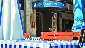 Ein Hotel-Stand mit einer blau-weiß karierten Tischdecke, roten Bänken und einem Schild mit der Aufschrift 'Hotel STATION Smart Sta'.