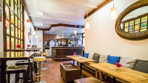 Ein Restaurantinneres mit Holztischen, gepolsterten Sitzgelegenheiten und einer Bar.