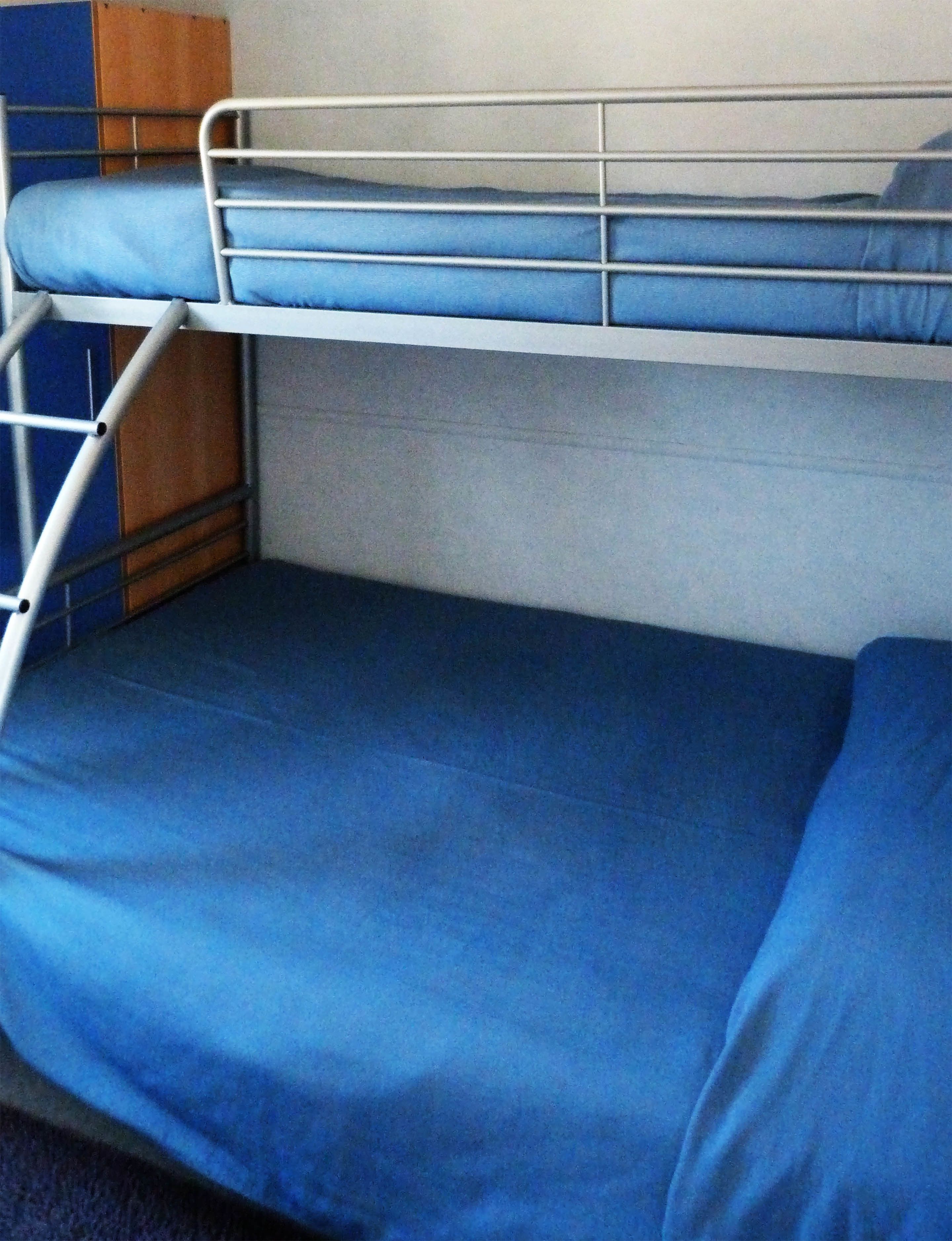 A bunk bed with blue bedding.