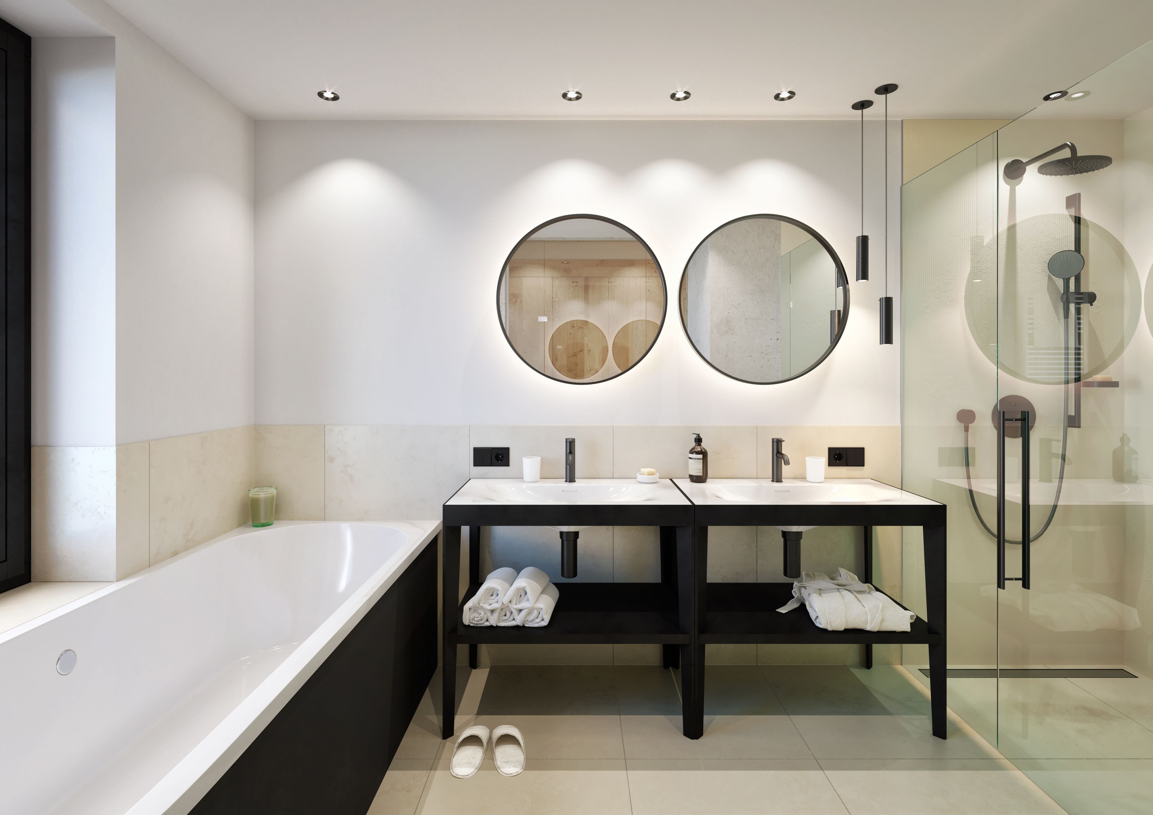 A modern bathroom with a large bathtub, two sinks, a glass-enclosed shower, and two round mirrors.