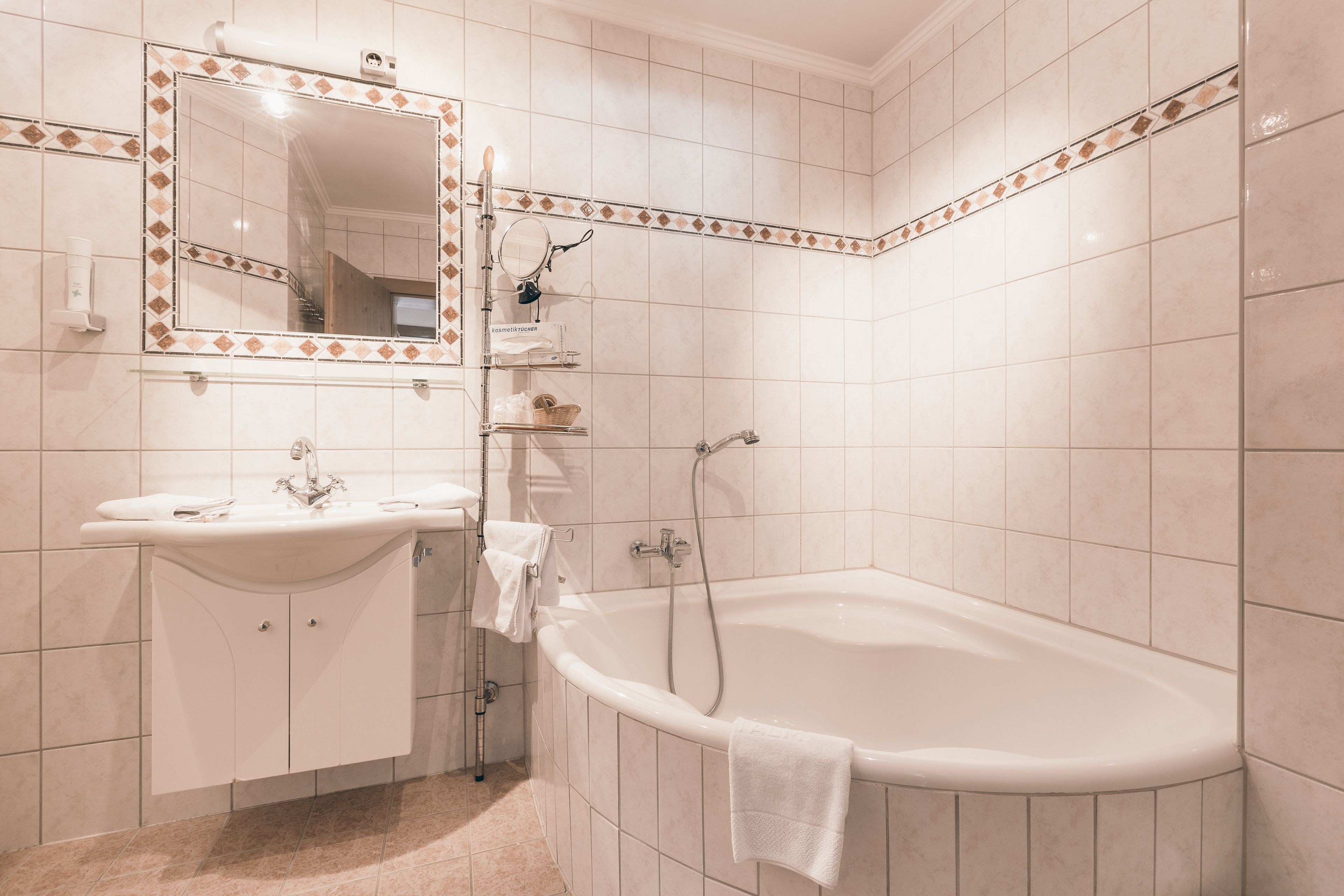 Un baño con lavamanos, espejo y bañera.