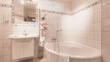 Un baño con lavamanos, espejo y bañera.