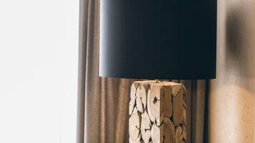 Eine moderne Lampe mit schwarz lackiertem Schirm auf Holzfuß.