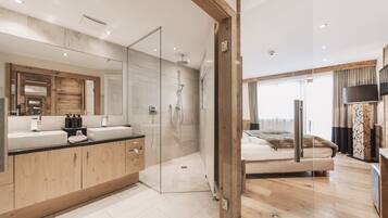 A modern bathroom with a glass shower enclosure, a wooden vanity, and a large mirror.